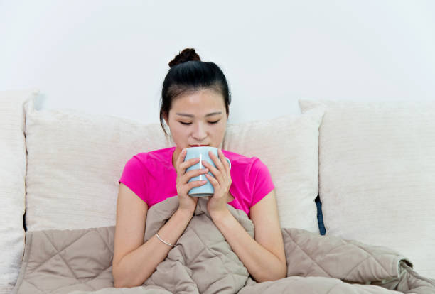 istock Sick woman holding  cup of tea 956357362