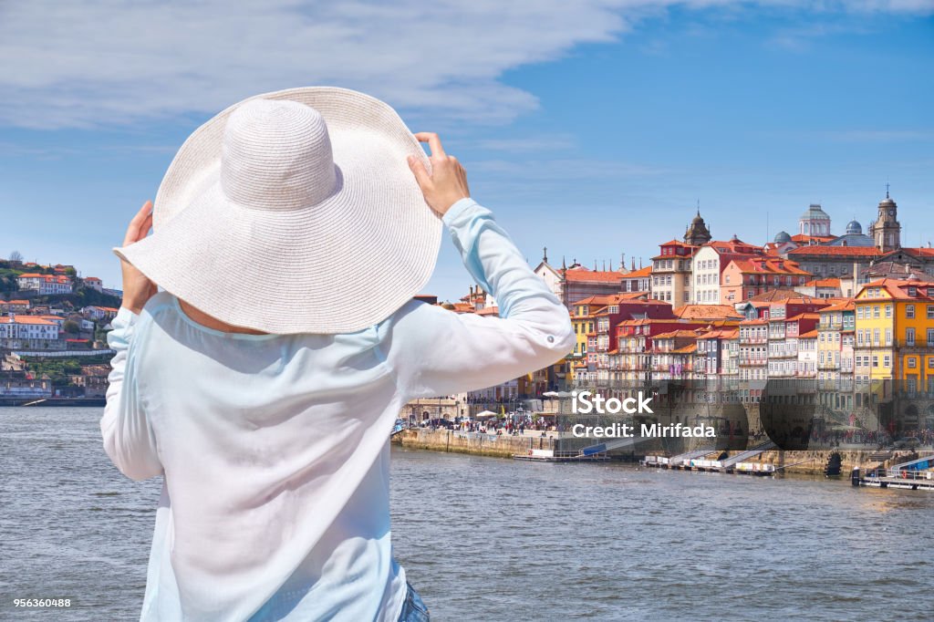 Woman in hat in Porto city, tourist on the waterfront. Woman in hat in Porto city, tourist on the waterfront. Portugal Porto - Portugal Stock Photo