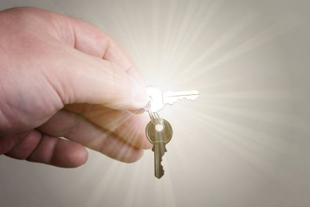 istock closeup of hand holding small cylinder lock keys with sun glow effect 956362094