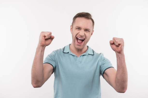 istock Joyful positive man clenching fists 956368126