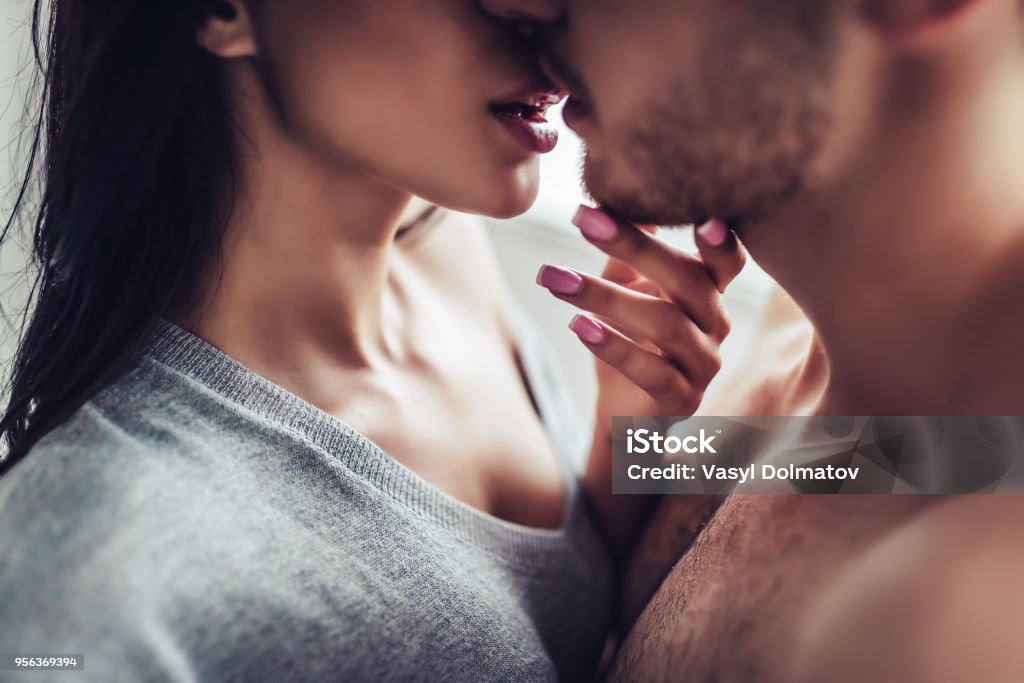 Love couple at home Close-up of young romantic couple is kissing and enjoying the company of each other at home. Sensuality Stock Photo