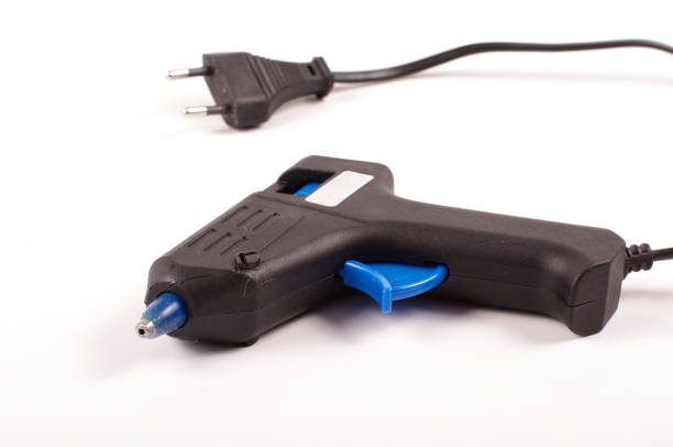 istock Glue gun for heating glue sticks isolated on the white background 956369916