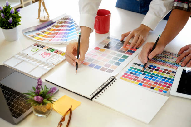 istock Team graphic designer at work. Graphic designer working colour tone with sketching something paper, tablet and computer in studio  office. 956372276