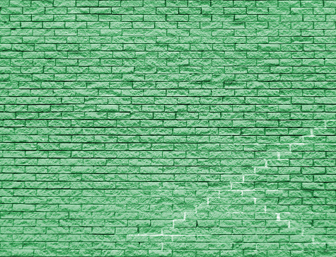 A toned green brick wall background with old cracks and textures