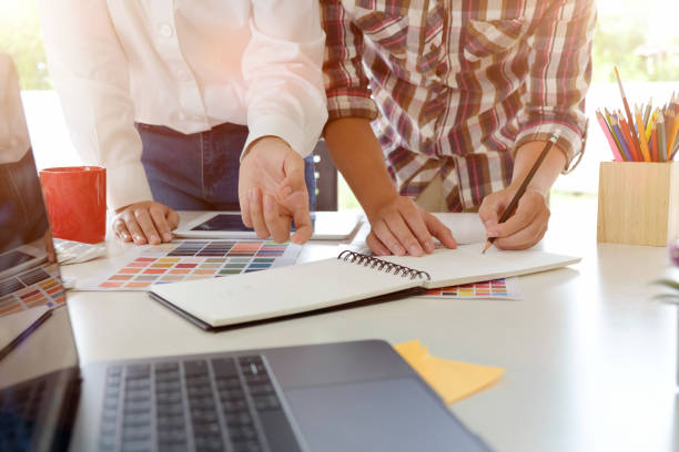 istock Team graphic designer at work. Graphic designer working colour tone paper, tablet and computer in office. 956372364