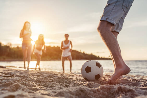 grupo de amigos en la playa - beach football fotografías e imágenes de stock