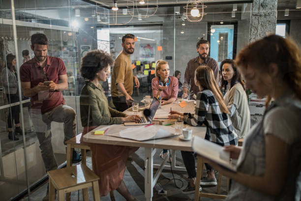 istock Large group of multi-tasking freelance workers at casual office. 956377770