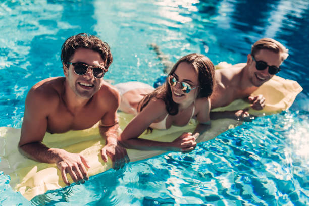 istock Young friends in swimming pool 956379154