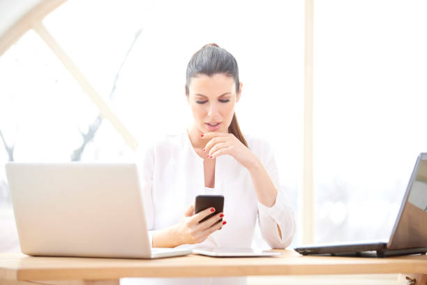 istock Businesswoman using cell phone and laptops 956386270