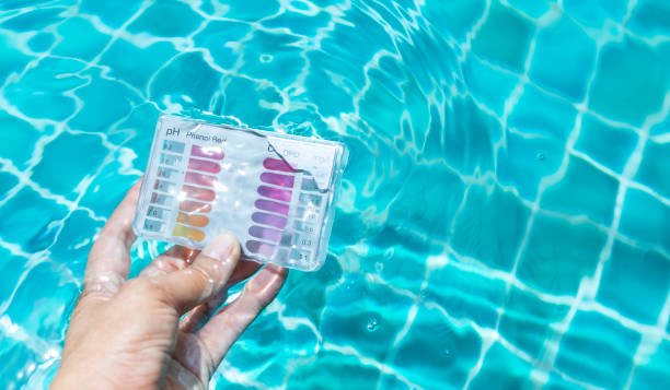 Swimming pool check kit in girl hand dipping in clear water Swimming pool check kit in girl hand dipping in clear water, summer outdoor day light, water quality test kit chlorine stock pictures, royalty-free photos & images