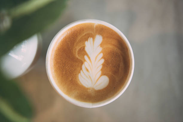istock latte or Cappuccino with frothy foam, coffee cup top view on table in cafe. 956391112