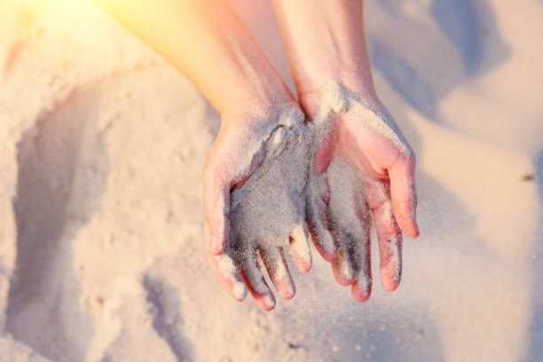 istock female hands pour sand on the ground 956396106
