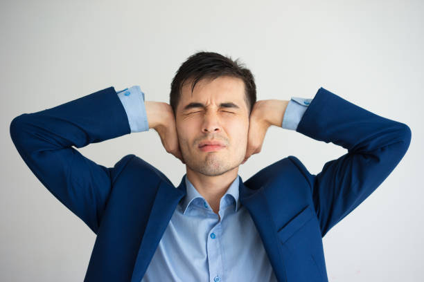 Annoyed man covering ears with hands with his eyes closed Annoyed man covering ears with hands with his eyes closed. Annoyance concept. Isolated front view on white background. man closing ears photos stock pictures, royalty-free photos & images