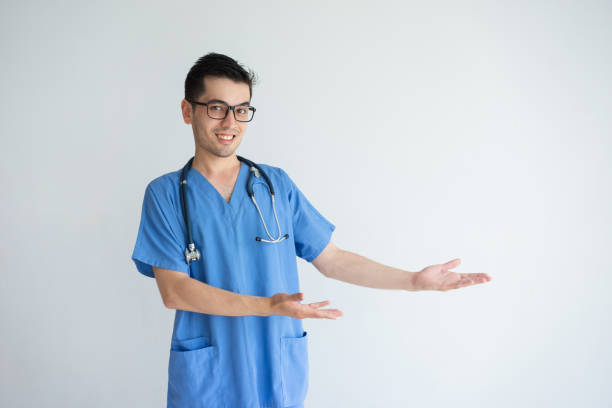 istock Happy male doctor pointing at empty space and presenting product 956400484