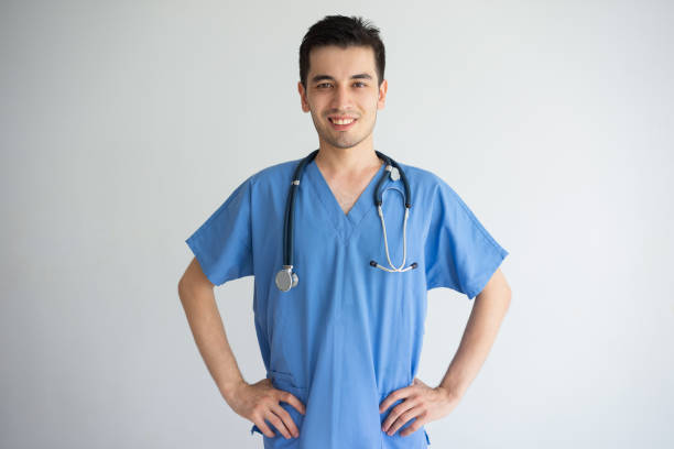 istock Confident young male doctor standing and keeping hands on hips 956400552
