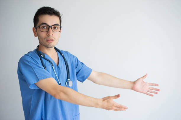 istock Serious male doctor pointing at empty space 956400602