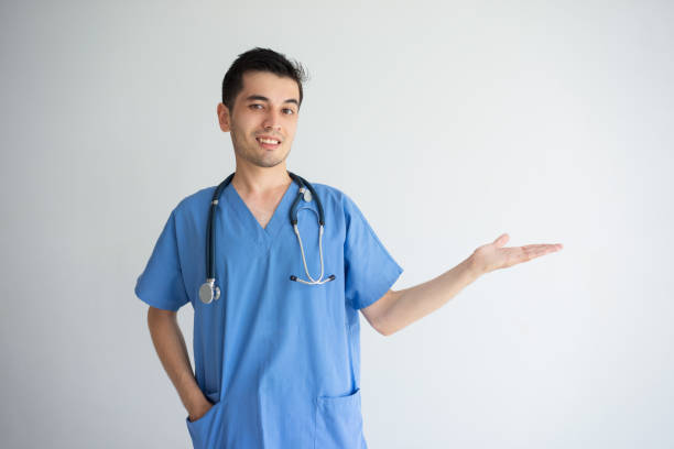 istock Smiling male doctor holding empty space on palm 956400852