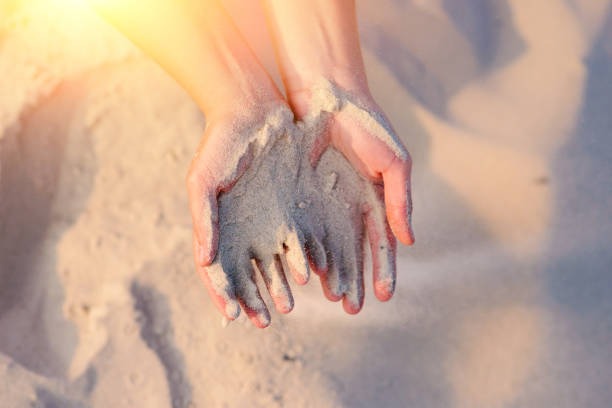 istock female hands pour sand on the ground 956401518