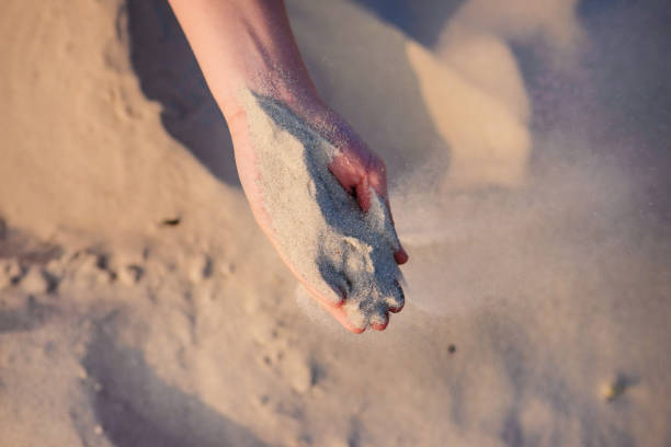 istock female hands pour sand on the ground 956401536