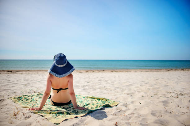 istock young woman in a blue hat Relaxing At Tropical Beach 956401630