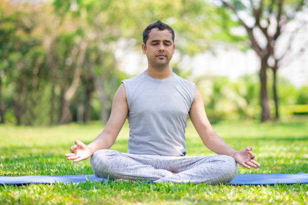 istock Serene Indian guy practicing yoga outdoors in park 956403130