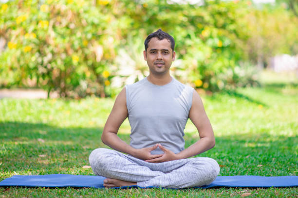 istock Serene Indian yogi doing asanas and training breathing 956403160