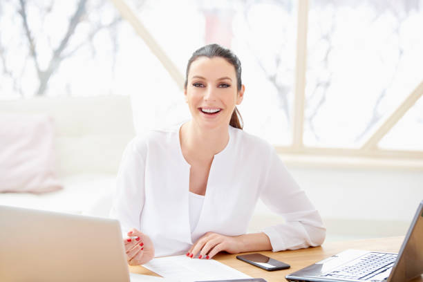 istock Young businesswoman writing something while sitting at office desk 956423082