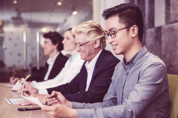 istock Happy Asian businessman sitting at conference 956426658