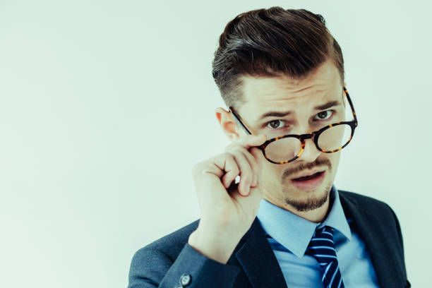 istock Surprised young businessman looking over glasses 956426722