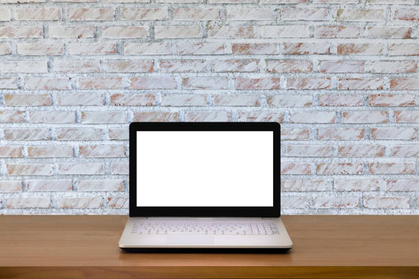 istock Laptop with blank screen on wooden table with modern interior background.Mock up business concept. 956432220