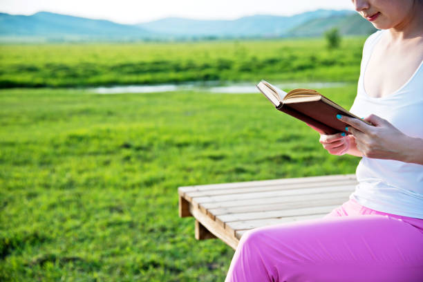istock Young woman reading in the nature 956435866