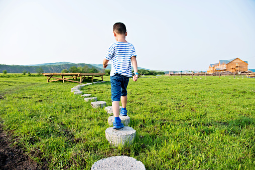 Boy walking on stepping concrete