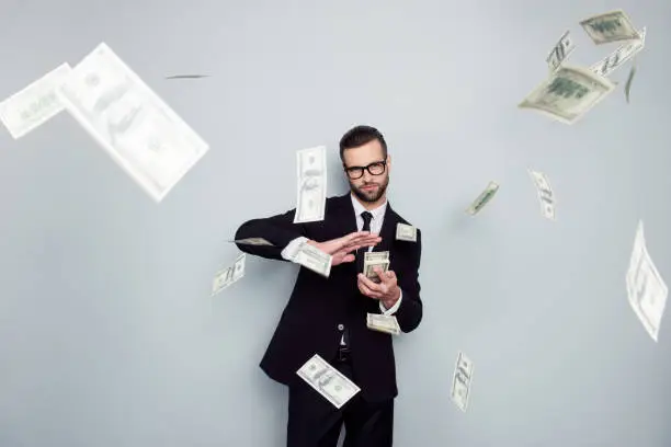 Photo of Spectacles jackpot entrepreneur economist banker chic posh manager jacket concept. Handsome confident cunning clever wealthy rich luxury guy holding wasting stack of money isolated on gray background