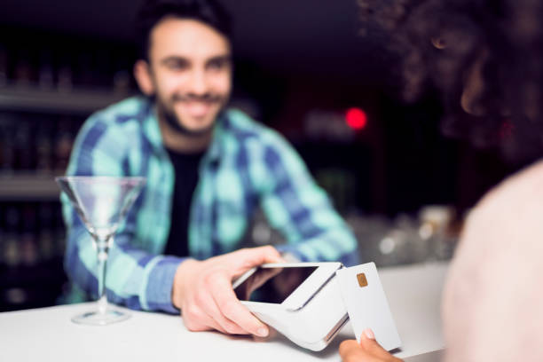 istock Brunette lady using credit card to pay contactlessly 956441790