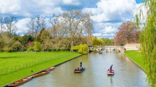 Cambridge, United Kingdom - June 17: People punting on river Cam on a bright sunny day, Cambridge, Cambridgeshire, United Kingdom