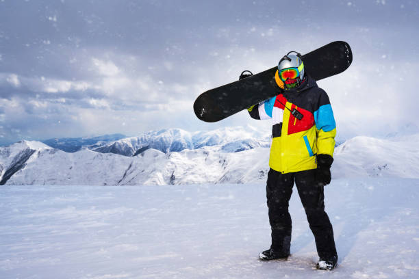 istock Snowboarder carries a snowboard in hand. 956450228