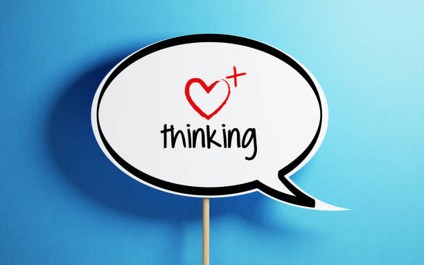 White chat bubble with wooden stick on blue background. Positive thinking writes on the speech bubble. Horizontal composition with copy space.