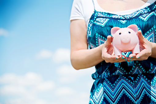 Woman holding a piggy bank in hands