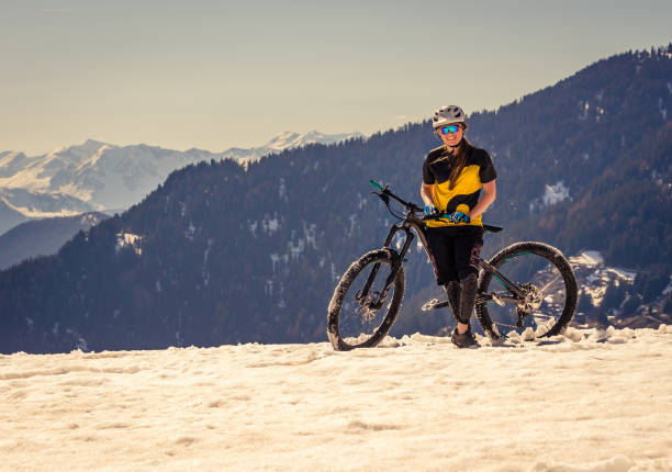 Mountain biker standing on the snow in the alps