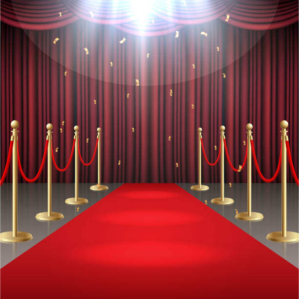 istock Red carpet and curtain and barrier rope in glow of spotlights 956459590