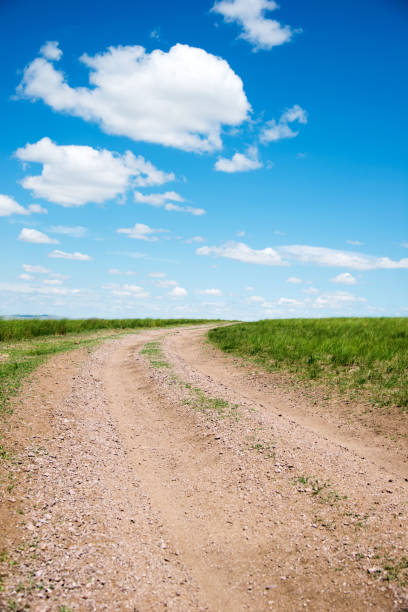 istock Dirt road and blue sky 956460476