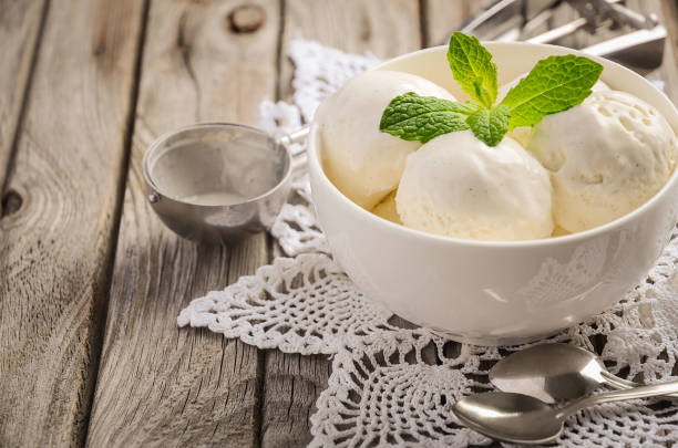 istock Vanilla ice cream with mint leaves in white bowl on rustic wooden background. 956472812
