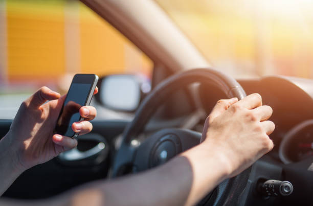 istock Careless young man texting a message while driving a car. 956479826