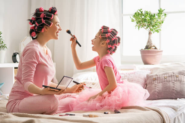 istock Mom and child doing hair 956487376