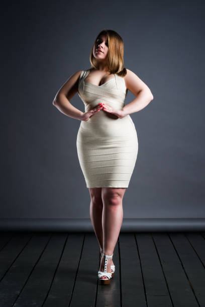 plus size fashion model in dress, fat woman on gray studio background, overweight female body - sex symbol sensuality women overweight imagens e fotografias de stock