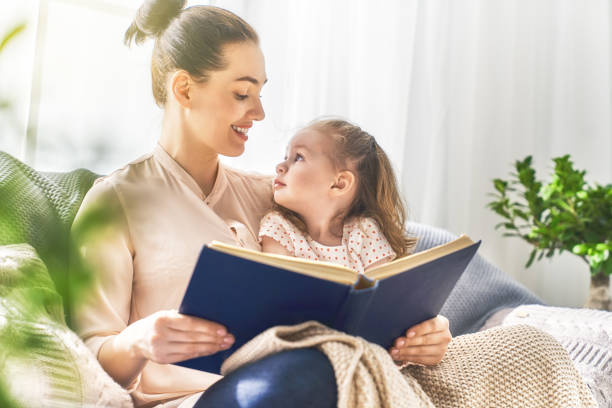 istock Mom and child reading a book 956492176