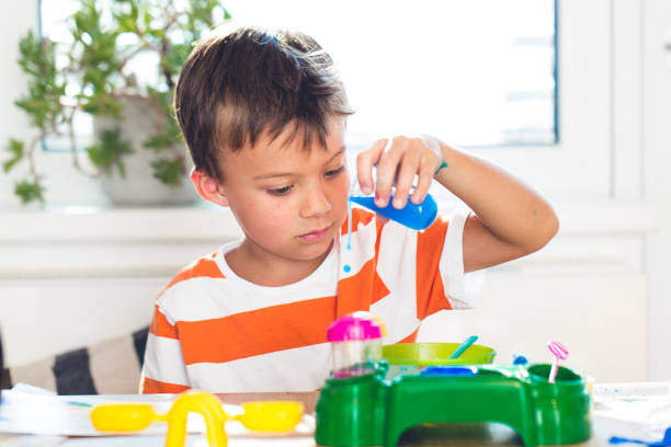 istock Boy Playing With Toys At Table Against Window 956492326