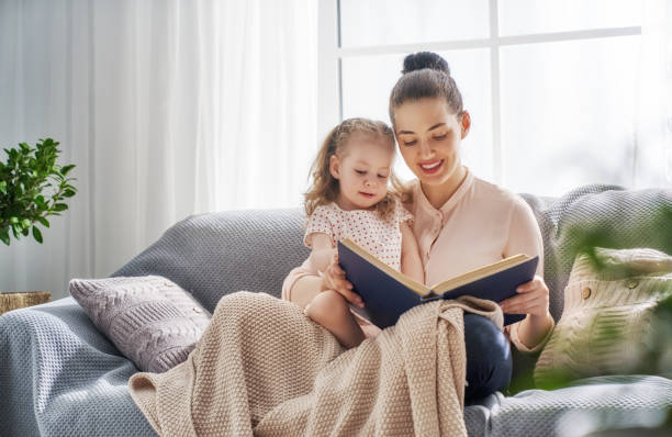 istock Mom and child reading a book 956492334