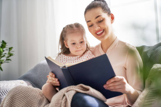 istock Mom and child reading a book 956492336