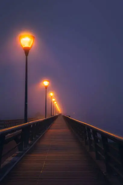 couple walking on dark street illuminated with streetlamps